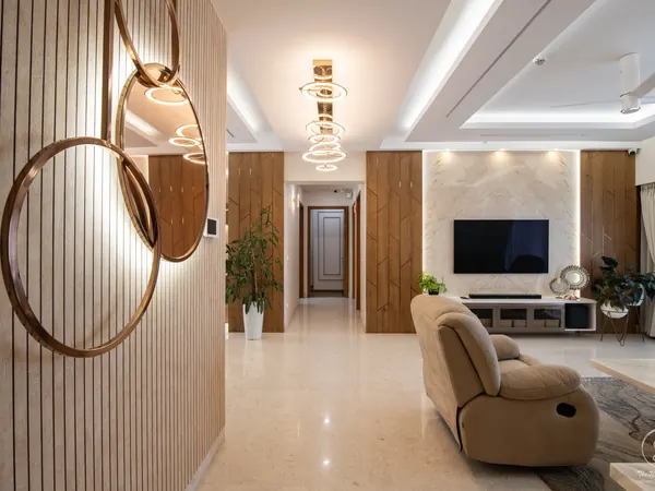 Living room with a round mirror on slatted wood, a recliner and a lit ceiling