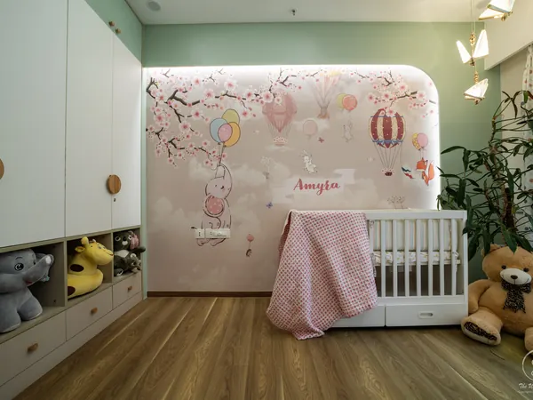 Nursery with a hand-painted balloon mural, a white cot and toy shelves