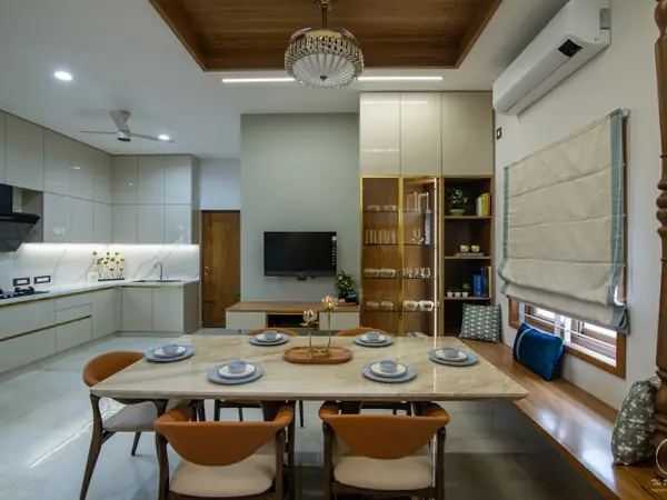 Dining table for eight beside a light grey kitchen