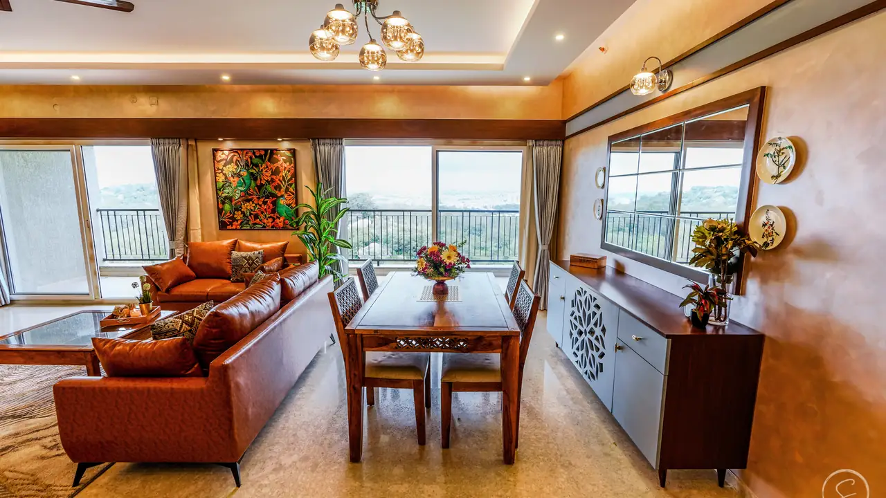 Living and dining room in rust and wood tones with a hill view