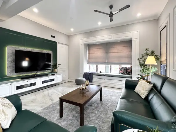 Living room with a deep green TV wall and green leather sofas