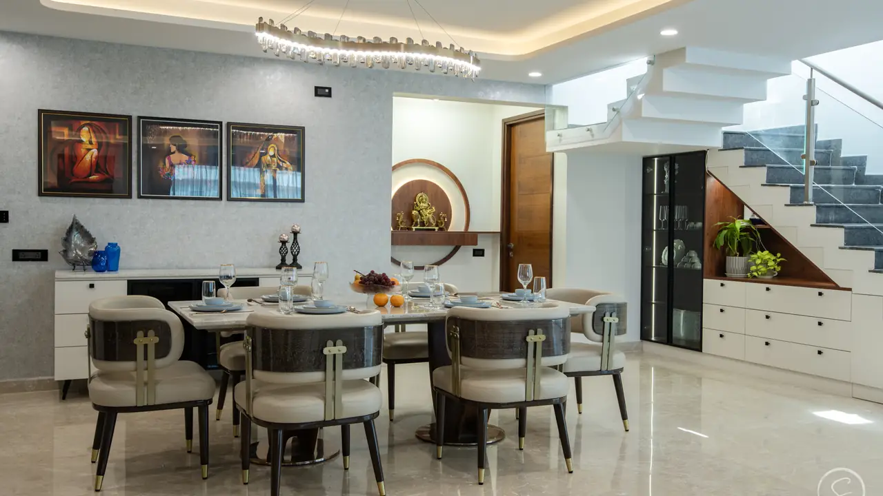 Dining room with a sculpted ceiling light beside a floating staircase