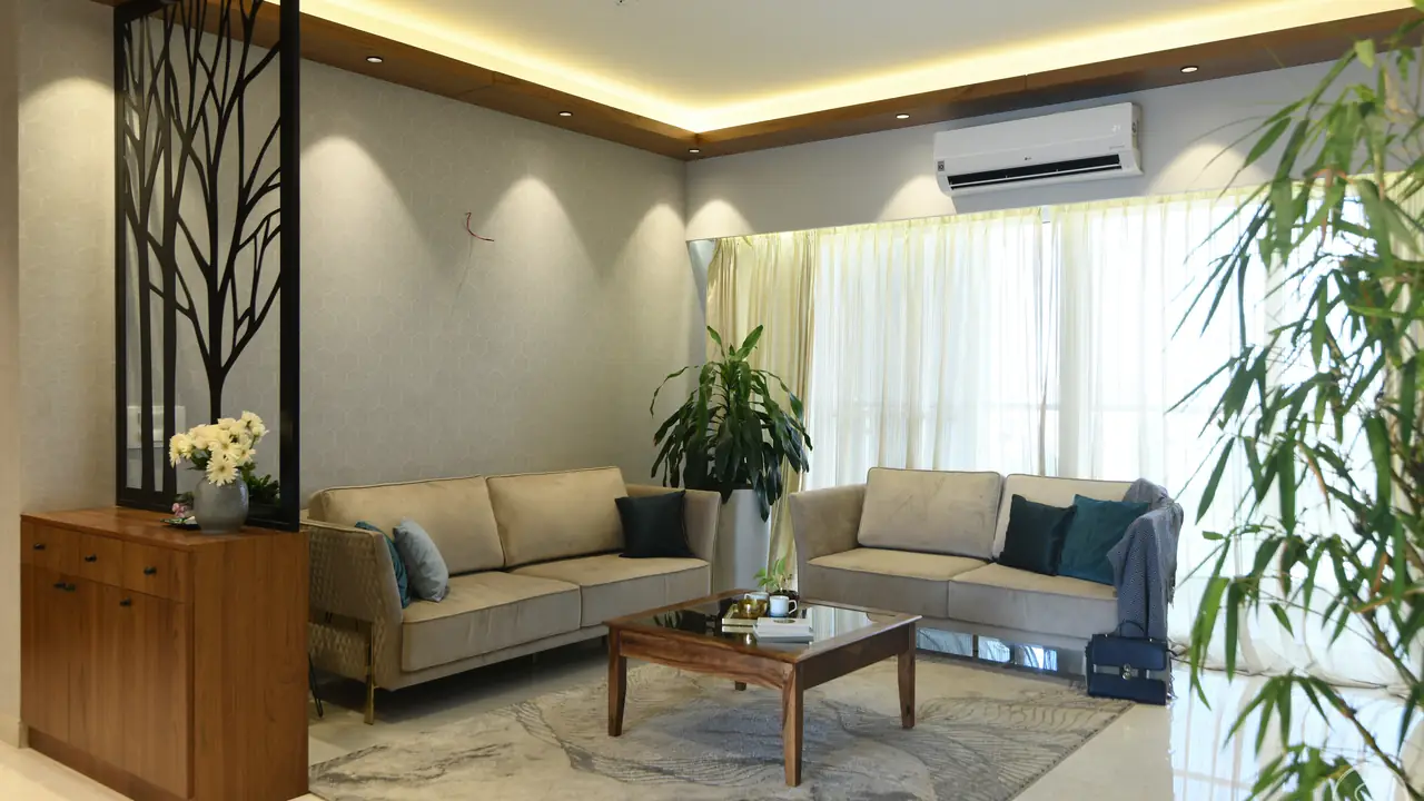 Living room with a metal tree screen and beige sofas