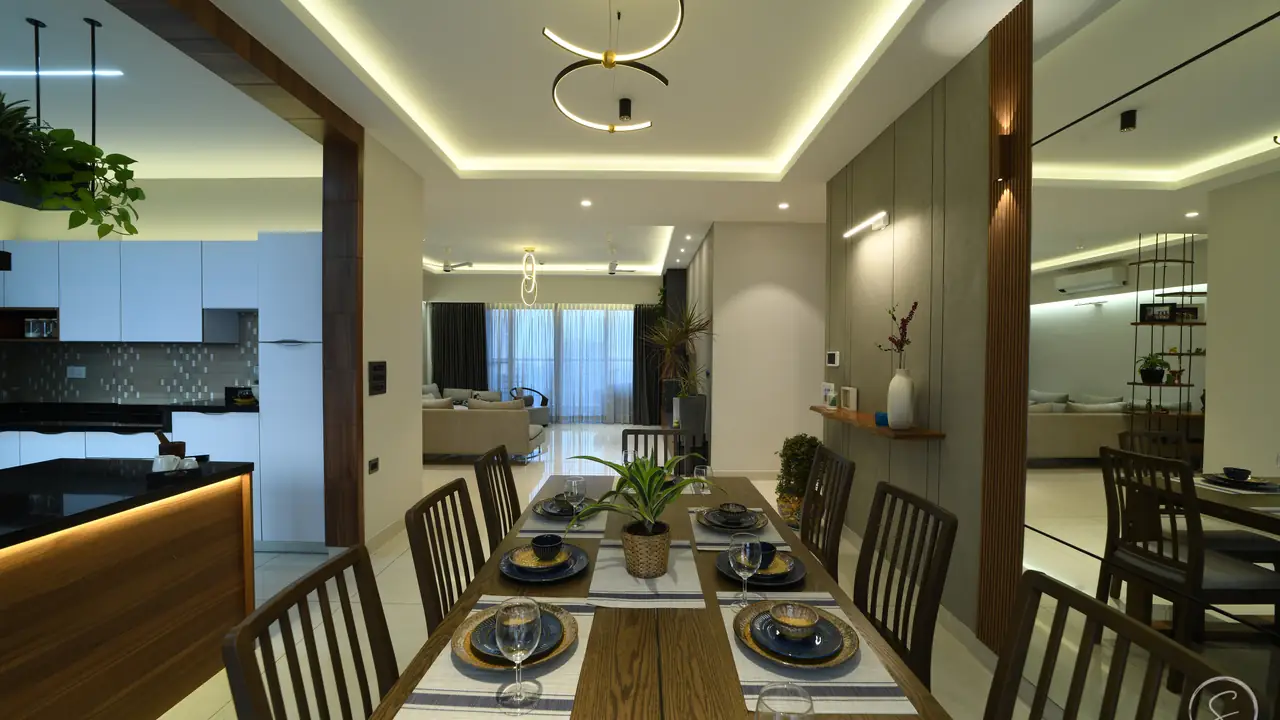 Dining area with a ring pendant light, cove-lit ceiling and a wood-and-glass partition