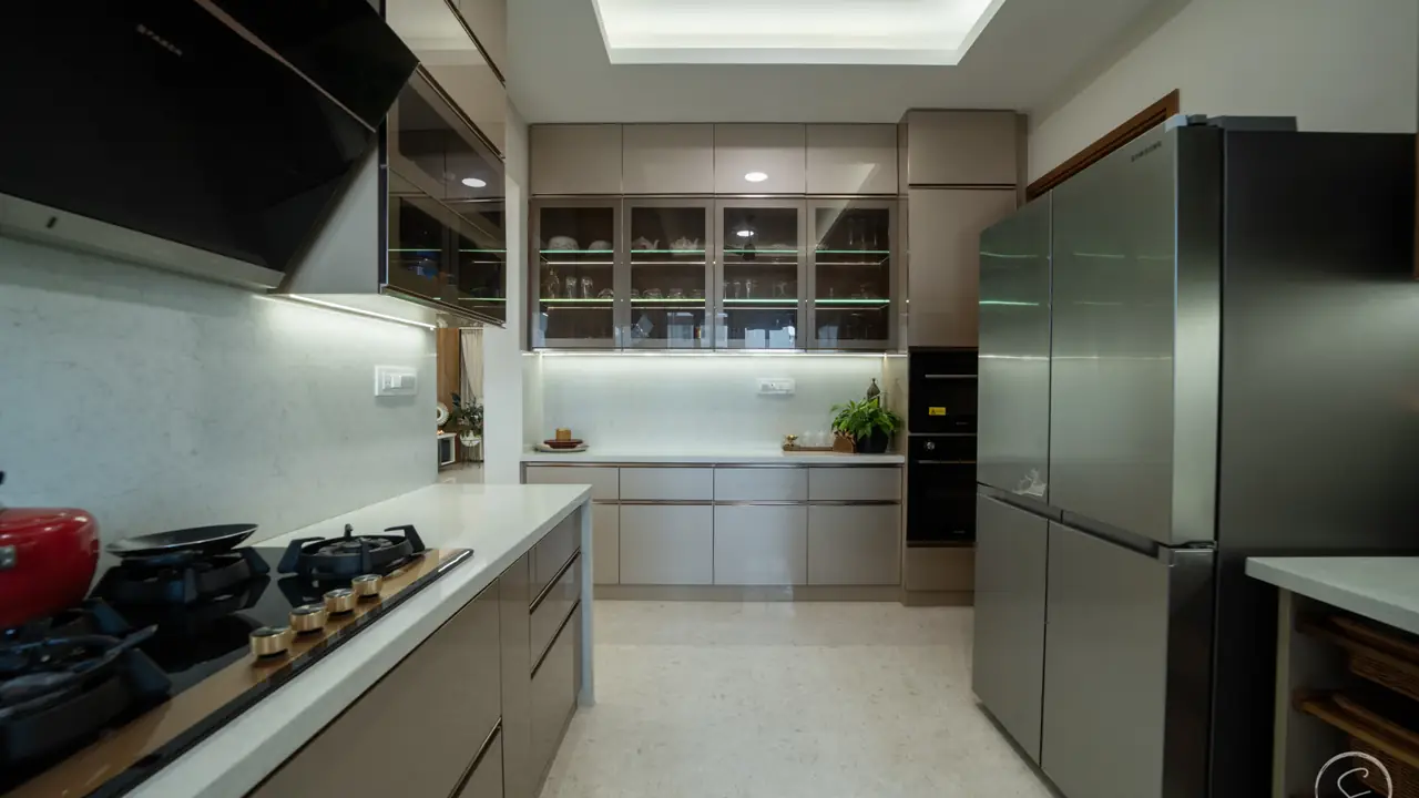 Kitchen with grey modular units, a glass-fronted upper cabinet and a black refrigerator