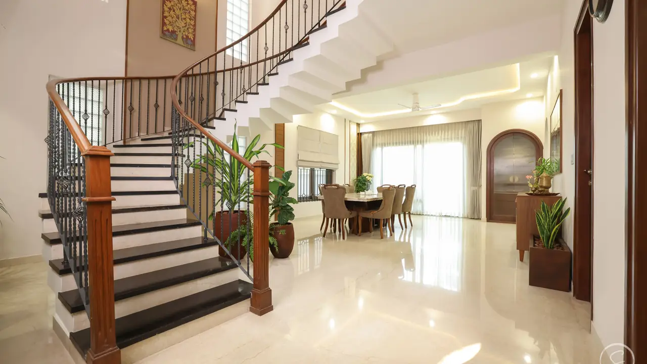 Double-height villa hall with a curved staircase