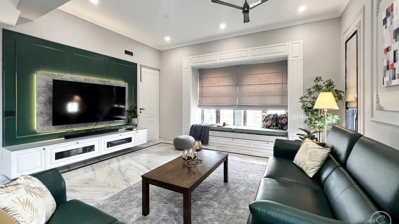 Living room with a deep green TV wall, a window seat and green leather sofas