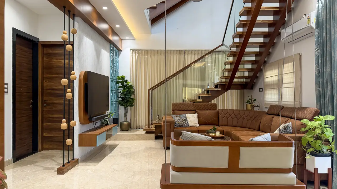 Villa living room with a timber staircase, a swing seat and a wall-mounted TV unit
